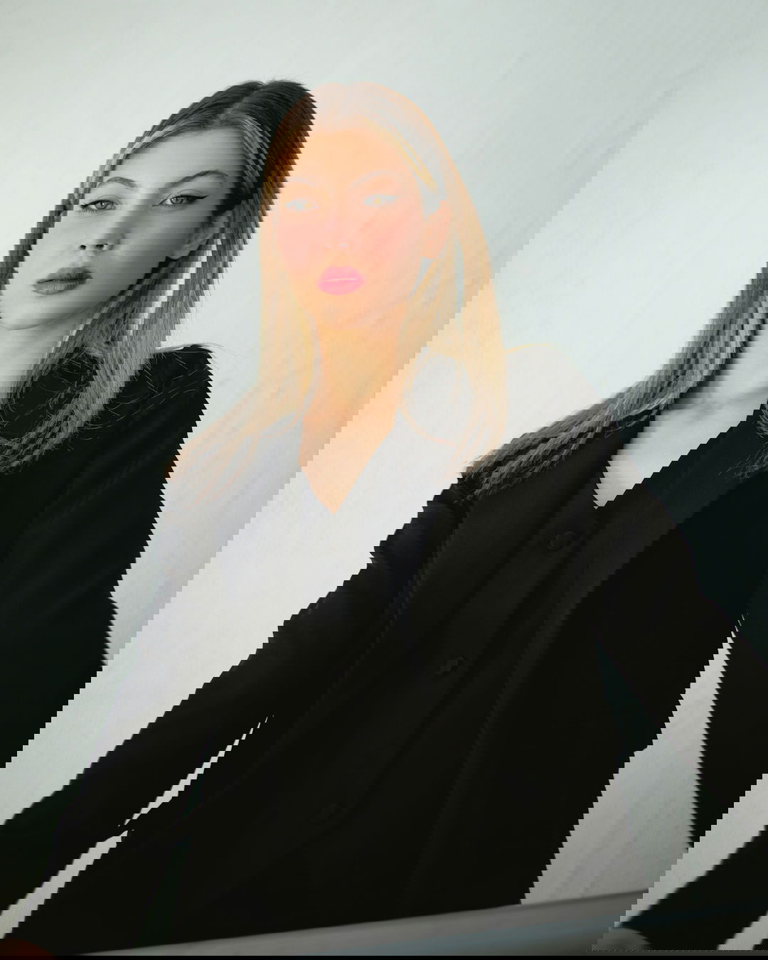 a woman in a black suit and red lipstick